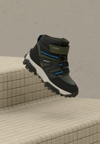 Juodas ir alyvuogių žalios spalvos žygio botas su nepralaidžiu audiniu, tinklelio detalėmis, mėlynomis akcentais ir tvirta balta padu. Reguliuojamos raišteliai pritaikymui.