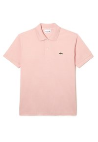 Polo rose en coton, doté d'un col classique, d'une patte de boutonnage à trois boutons, de manches courtes et d'un petit logo vert Lacoste sur la poitrine.