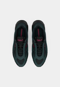 Par crnih i tamnozelenih Air Max tenisica s crvenim logotipima, prikazanih odozgo na bijeloj pozadini.