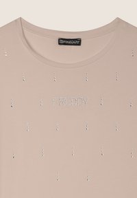 T-shirt beige chiaro a maniche corte, decorato con pietre di strass argentate sparse e la parola "FREDDY" in strass sul petto.