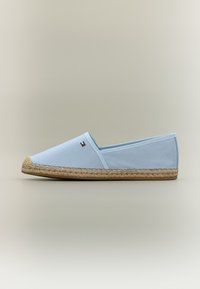 Espadrille en toile bleu clair avec une semelle en corde de jute. Présente un design minimaliste et un petit détail de marque sur le côté.