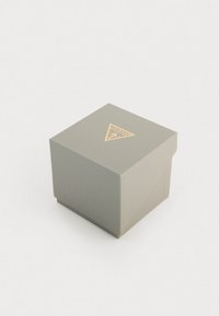 Caja de regalo texturizada en color gris con un logo triangular dorado en la parte superior, que cuenta con una tapa con bisagra y forma cuadrada para un cierre seguro.