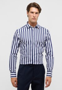 Langarm overhemd met verticale strepen in marineblauw en wit. Gemaakt van katoen, met een moderne kraag en contrasterende manchetten.