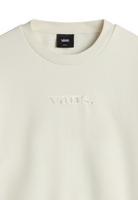 Sweat-shirt Vans col rond écru avec logo Vans embossé centré sur la poitrine et étiquette de taille noire à l'intérieur du col.