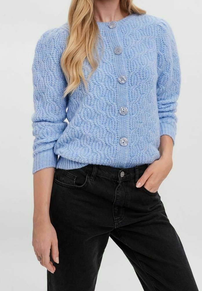 Ljusblå stickad kofta med ett strukturerat mönster, med rund hals, långa ärmar och fem stora grå knappar på framsidan.