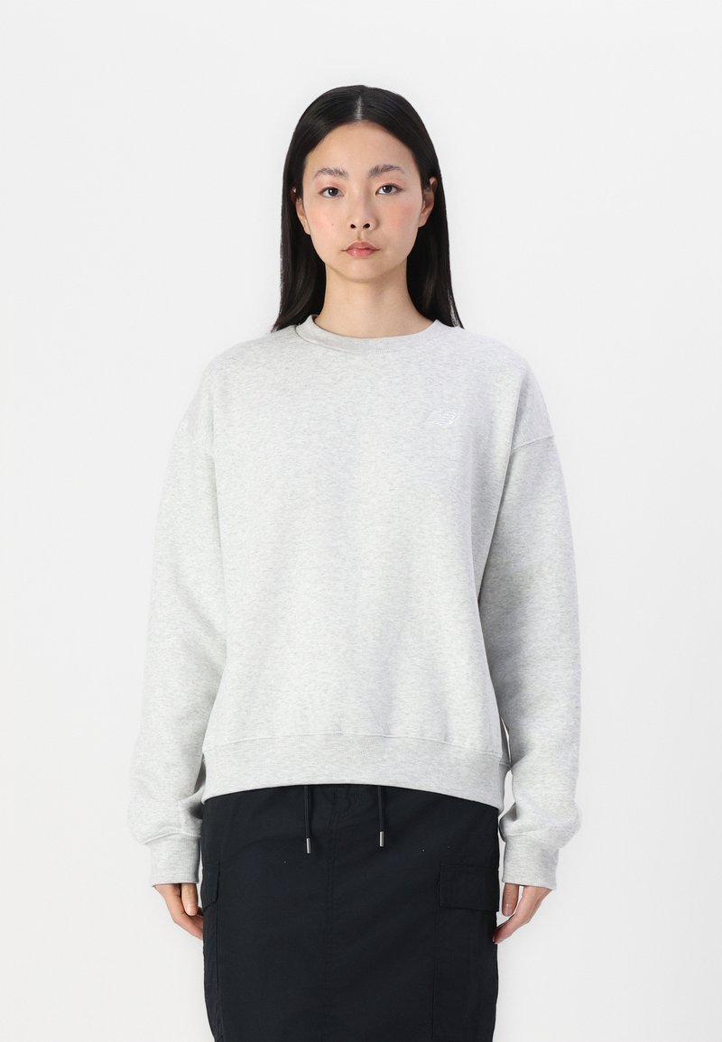Lichtgrijze sweatshirt met een ronde hals, verlaagde schouders en geribbelde mouwen. Heeft een subtiele logo op de borst en een relaxte pasvorm.