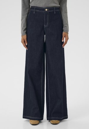 Pantalons en denim à jambes larges de couleur bleu foncé avec des coutures contrastées, une fermeture éclair et un devant plat. Fabriqués en tissu coton résistant.