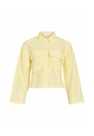 Světlounce žlutá krajková bunda s dlouhým rukávem, límcem, zapínáním na knoflíky vpředu a dvěma velkými klopovými kapsami na hrudi.