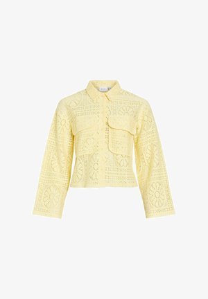 Světlounce žlutá krajková bunda s dlouhým rukávem, límcem, zapínáním na knoflíky vpředu a dvěma velkými klopovými kapsami na hrudi.