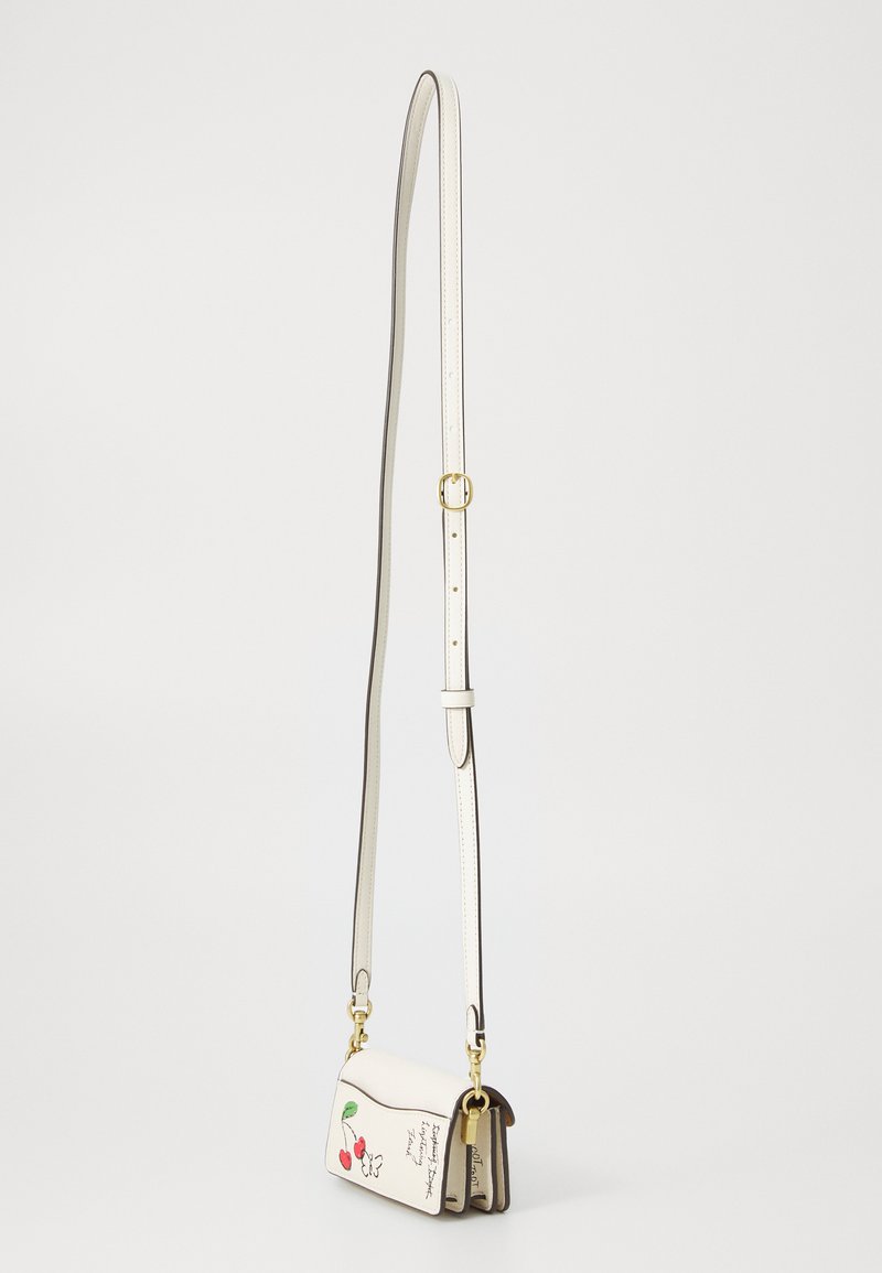 Sac bandoulière en cuir blanc avec une bandoulière amovible, décoré d'un motif floral et cerise, avec des finitions dorées et une forme rectangulaire compacte.