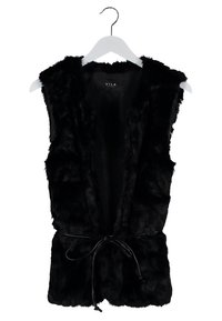 Musta keinoturkisliivi, jossa hihaton malli, edessä solmittava kiinnitys ja pehmeä, teksturoitu pinta. Ripustettu valkoiseen henkariin.