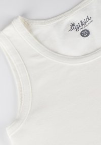 White sleeveless cotton tank top with a round neckline, featuring visible stitching. Label reads "sigikid" and size "104 (4Y)."