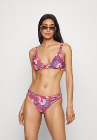 Blumen-Bikini-Set in Pink mit grünen Blättern, bestehend aus einem dreieckigen Oberteil mit goldenen Akzenten und passenden tief sitzenden Unterteilen. Glatte Stofftextur.