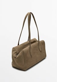 Borsa in suede marrone di forma rettangolare, con due manici lunghi e una chiusura con zip nella parte superiore. Presenta bordi lisci e una superficie strutturata.