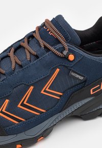 Vedenjästvi mõrv, millel on tume sinine kangas ülemine osa oranžide aktsentidega, robustne must tald ja kontrastsed jõnksud.