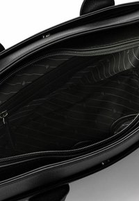 Bolso de mano de cuero negro con cierre de cremallera. El interior tiene un forro liso y con patrón, con un bolsillo con cremallera y amplio espacio para objetos.