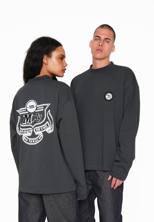 Dark gray long-sleeve sweatshirt with a round neckline. Features a large graphic print on the back and a smaller logo on the front.