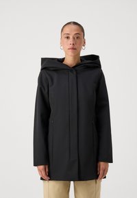 Crna vodootporna jakna s visokim ovratnikom, velikom kapuljačom, zatvorenim bočnim džepovima i elegantnim dizajnom. Glatka tekstura, dužine do sredine bedra.