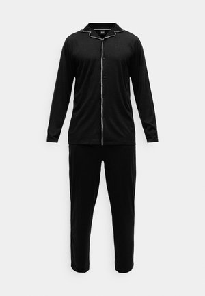 Black long-sleeve pajama set with white piping along the collar and buttons. Soft fabric and relaxed fit pants, straight leg design.