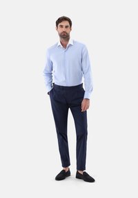 Helle blaue Button-Up-Hemd, marineblaue Hose und schwarze Slipper. Glatter Stoff; taillierte Passform mit klassischem Kragen. Einfaches Design.