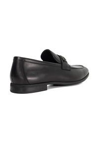 Black leather loafers with a rounded toe design, decorative buckle detail, and a flat rubber sole. Smooth texture with minimal stitching.