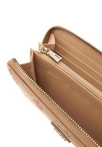 Portafoglio beige con esterno testurizzato, zip dorata e più scomparti per carte. L'interno presenta un comparto con zip per una conservazione sicura.