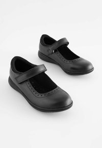 Schwarze Leder-Mary-Jane-Schuhe mit einem Klettverschluss, abgerundeter Zehenform und gestanzten Akzenten. Weiche Innenauskleidung und flache Sohle.