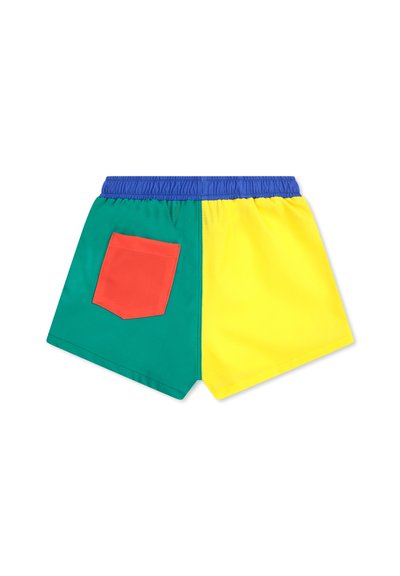 Pantaloni corti multicolori: tessuto verde e giallo, vita elasticizzata, rifiniture blu, con una tasca rossa a toppa sul lato verde.