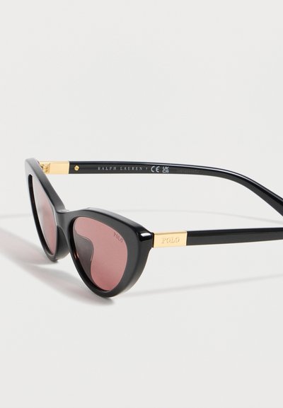 Μαύρα γυαλιά ηλίου cat-eye με ροζ φακούς, χρυσές λεπτομέρειες, λογότυπο "POLO" στους βραχίονες και κείμενο "RALPH LAUREN" στο εσωτερικό των βραχιόνων.