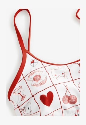 Czerwona i biała koszulka na ramiączkach z wzorem w kratkę, z rysunkowymi motywami, takimi jak serca, wiśnie i wzory florystyczne. Czerwony nadruk wokół dekoltu.