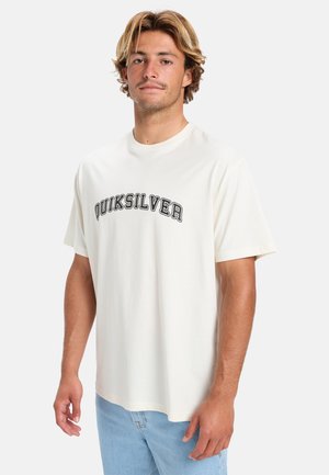 Krém színű, rövid ujjú, pamut póló. Az elején fekete "Quiksilver" logó található, amely a mellkason helyezkedik el. Lazán illeszkedő fazon.
