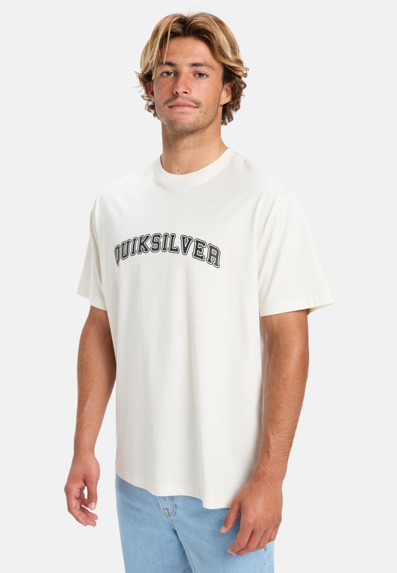 Cremefarvet t-shirt lavet af bomuld med korte ærmer. Har et sort "Quiksilver" logo trykt henover brystet. Casual pasform.