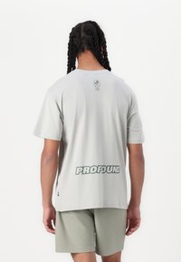 Lys grå kortærmet t-shirt med "PROFOUND" trykt i mørkegrøn på ryggen, lavet af bomuldsstof, afslappet pasform og rund halsudskæring.