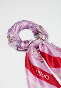 Bufanda de seda en tonos rosas con un patrón decorativo y un acento rojo. Cuenta con una textura suave y un diseño anudado para darle estilo.