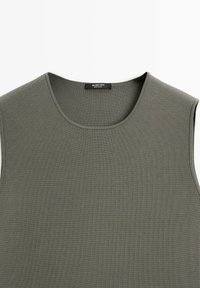 Khakifarbenes ärmelloses Top aus geripptem Stoff. Verfügt über einen runden Halsausschnitt und eine glatte Textur. Das Etikett lautet "Massimo Dutti."