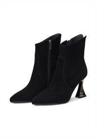 Crne antilop čizme do gležnjeva s oštrim vrhom, bočnim patentnim zatvaračem i jedinstvenom, zakrivljenom crnom petom s prugastim akcentom.