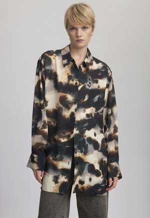Camicia a maniche lunghe con un motivo astratto in nero, marrone e crema, con chiusura a bottoni sul davanti, realizzata in un tessuto liscio e lucido.