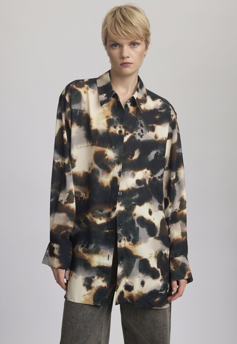 Camicia a maniche lunghe con un motivo astratto in nero, marrone e crema, con chiusura a bottoni sul davanti, realizzata in un tessuto liscio e lucido.