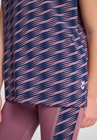 Marinblå och rosa mönstrad sporttopp med korta ärmar och avslappnad passform, kombinerad med mauve leggings med sidostrimma.