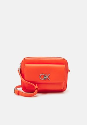 Fel oranje rechthoekige crossbodytas met voorvak, zilveren gesp logo en verstelbare band op witte achtergrond.