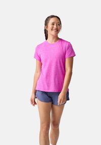Svetlo ružové atletické tričko s krátkym rukávom a jemnou textúrou, skombinované s tmavo námorníckymi šortkami. Vhodné na šport alebo voľný čas.