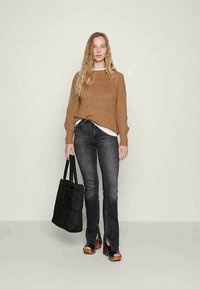 Brown knit sweater, white shirt underneath, gray flared jeans, black tote bag, and brown platform shoes. Straight hair, frontal pose.