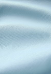 Tissu bleu clair avec une texture lisse et des plis doux créant des ombres et des reflets délicats.