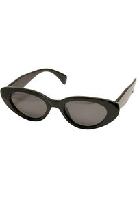 Occhiali da sole neri a forma di occhi di gatto con lenti scure, realizzati in plastica lucida. Presentano montature spesse e templi curvi. Nessun hardware o motivo aggiuntivo.