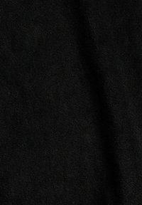 Tissu noir texturé avec un motif tissé visible et des plis doux.