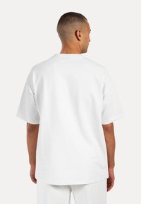 Weißes kurzärmliges T-Shirt mit lockerer Passform, Rundhalsausschnitt und glattem Stoff. Sichtbare Nähte entlang der Nähte und Rückendetail.