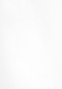 Due adulti e un bambino che camminano mano nella mano su un sentiero lastricato con erba e lampioni in una giornata nuvolosa.