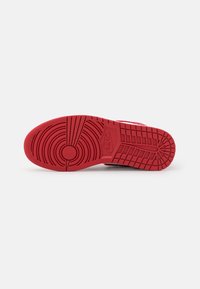Červená gumová podešev s kruhovými a liniovými vzory; logo značky je.embosované blízko paty. Zpevněný okraj pro zvýšení odolnosti.