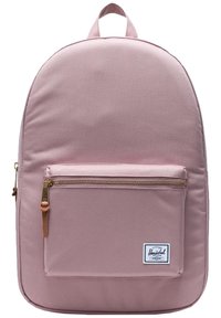 Mochila de tela rosa con forma redondeada. El bolsillo frontal con cremallera cuenta con una cremallera dorada. Incluye un asa superior y una etiqueta de logo en la parte inferior.