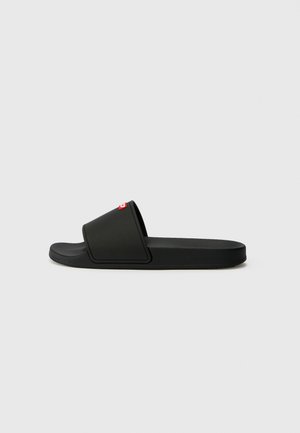 Black slide sandal with a molded footbed, smooth plastic straps, and a red logo accent on the upper. Minimalist design and flat sole.
